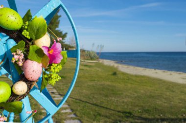 renkli Paskalya yumurtaları ve denizin kenarında çiçek şube