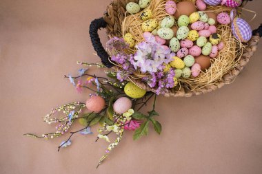 Paskalya Paskalya yumurtaları ve bahar çiçekleri ile arka plan. Kraft kağıt üzerinde kopya alanı ile Üstten Görünüm.