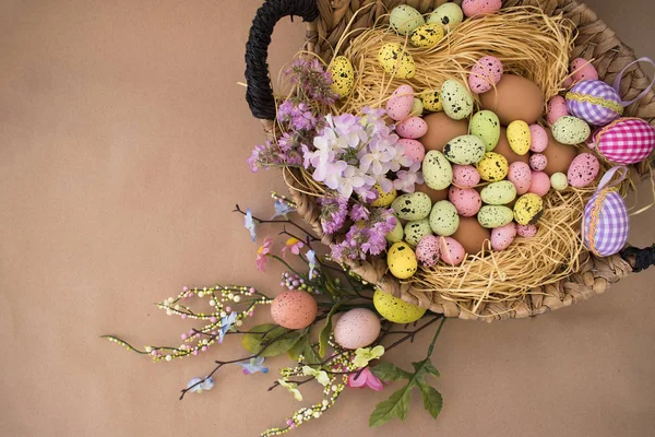 Easter background with Easter eggs and spring flowers. Top view with copy space on craft paper. — Stock Photo, Image