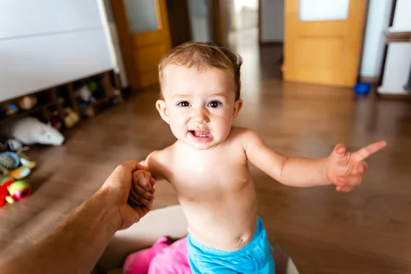 Pretty and adorable one-year-old girl learning to walk smiles wh — Stock Photo, Image