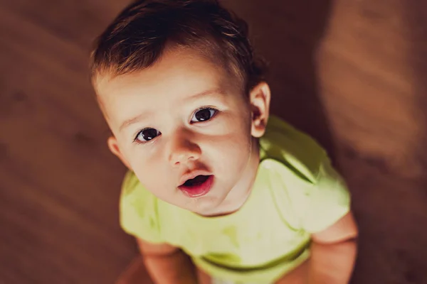 Bebé sentado mirando hacia la cámara en él con intrigado ge — Foto de Stock