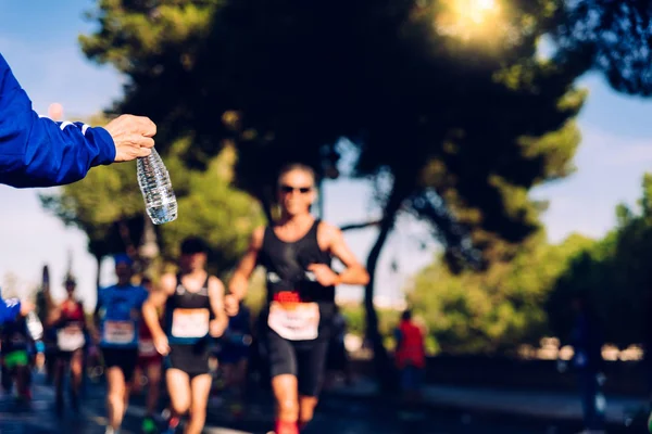 Runner coleta uma garrafa de água para hidratar durante um treino . — Fotografia de Stock