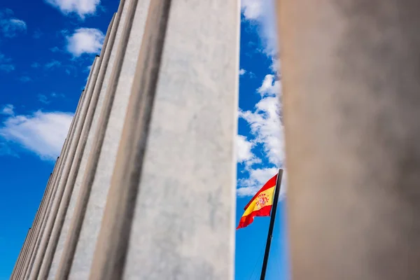 Bandera de España ondeando vista entre las barras de una frontera, concepto o — Foto de Stock