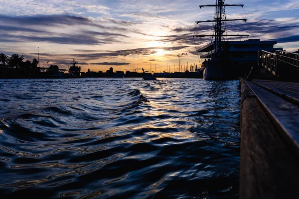 Veleiro atracado no porto com um belo pôr do sol . — Fotografia de Stock