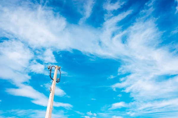 Starý sloup na nepoužité elektrické kabely s modrou oblohou a clo — Stock fotografie