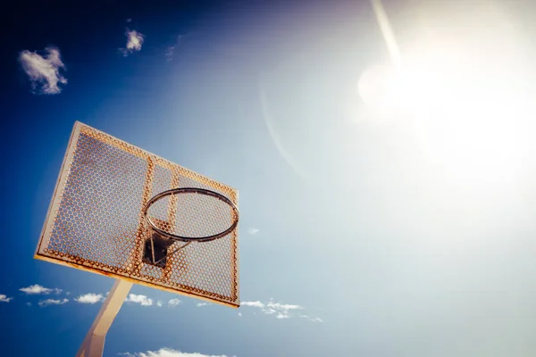 Cesta de basquete em uma quadra ao ar livre com um sol intenso com d — Fotografia de Stock