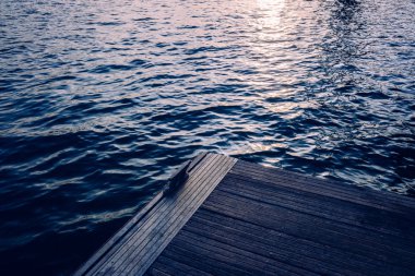 Bir deniz suyu iskelesinde gün batımı, retro mavi eski tonlar, bir olarak 