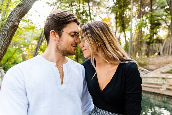 Man and woman in love in a park having a romantic kiss. — Stock Photo, Image