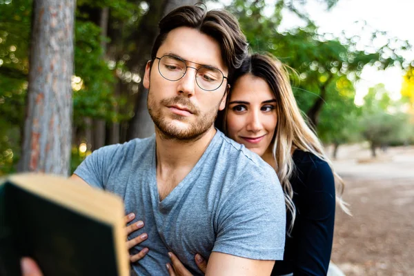 Casal apaixonado abraçando, leia um livro em um jardim natural . — Fotografia de Stock
