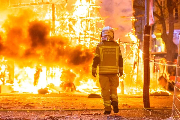 Feuerwehrmann mit Schutzanzug bei der Kontrolle des Bohrers — Stockfoto