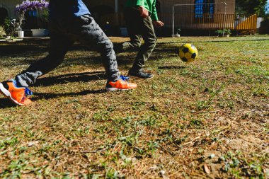 Summe'de bir dostluk maçında eski bir futbol toplarını kovalayan çocuklar