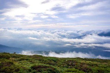 Bir dağın zirvesinin tepesinden bir kış bulutlu gökyüzü sahnesi.