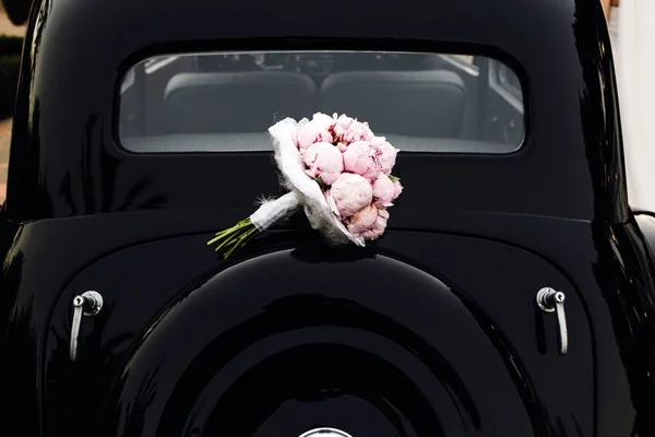 Ramo de flores de novia en la capucha de un coche vintage . —  Fotos de Stock