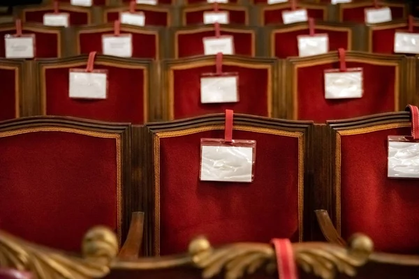 Fauteuils van een oud theater van rode stof, met blanco etiketten, voor — Stockfoto
