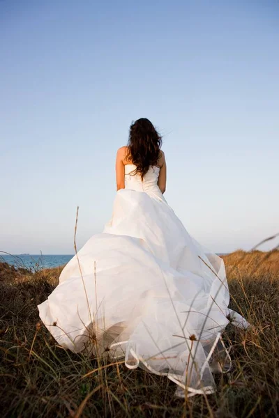 Mujer vestida de novia en un bosque colocando su tocado, vert —  Fotos de Stock