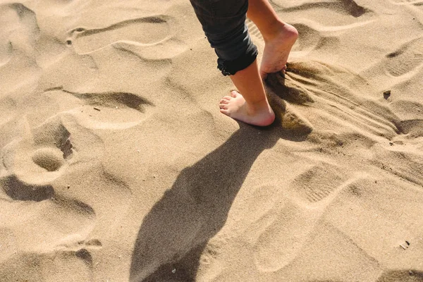 Pés de menino andando na areia da praia . — Fotografia de Stock