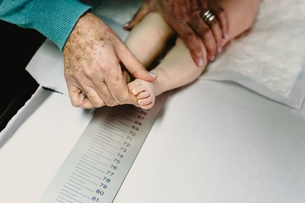 Newly born in the clinic of the pediatrician measuring a height — Stock Photo, Image