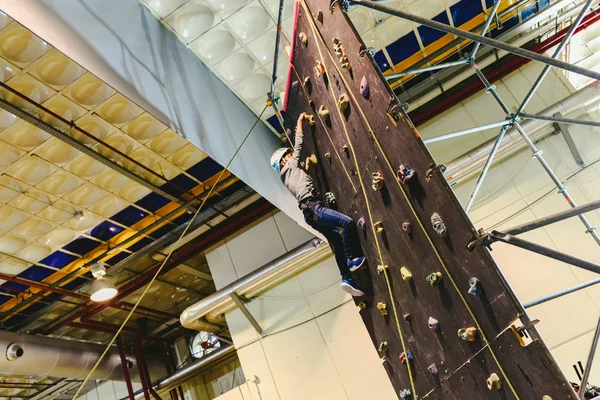 Jongen een klimwand klimmen naar de top te zijn angsten te overwinnen. — Stockfoto