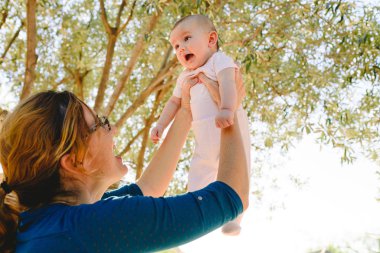 Yan görünüm Genç mutlu anne anne onu yeni doğan bebek yetiştirme oynarken