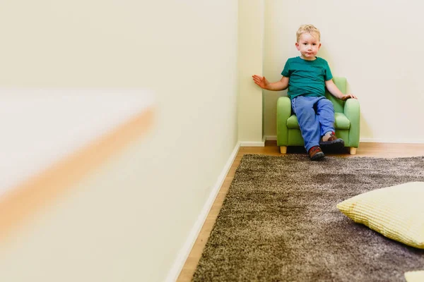 Niño de dos años sentado solo en un sillón . —  Fotos de Stock