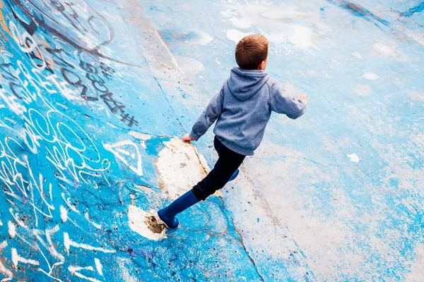 Niño merodeando dentro de una zona de patinaje abandonada, pintado de azul , — Foto de Stock