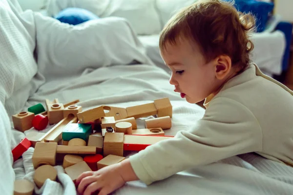 Baby has fun selecting wooden cubes to play with them and develo — стокове фото