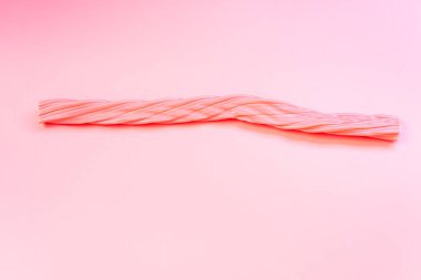 Düz bir arkaplanda izole edilmiş uzun pembe şekerler..