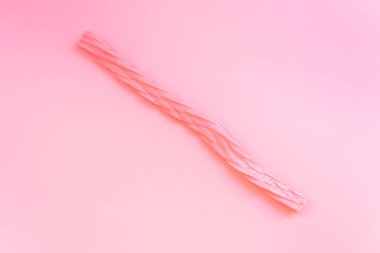 Düz bir arkaplanda izole edilmiş uzun pembe şekerler..