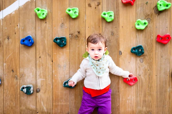 Retrato del bebé en un parque infantil con pared de escalada . —  Fotos de Stock