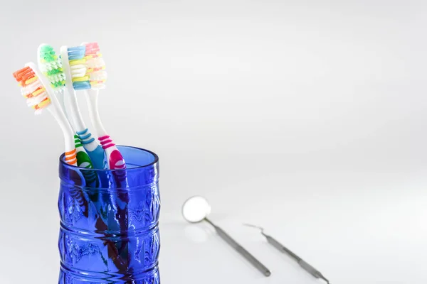 Zahnbürsten im Glas und Zahnpflege-Set isoliert auf weißem Ba — Stockfoto