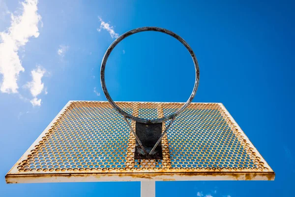 Een oude basketbalmand buiten een straat met blauwe lucht, kopieer sp — Stockfoto