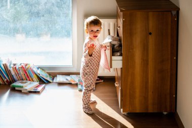 Pijamalı bebek yatak odasında çocuk hikayeleri izliyor.