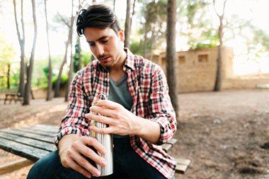 Plastik kullanmaktan kaçınmak için bir adamın tuttuğu yeniden kullanılabilir su şişesi.
