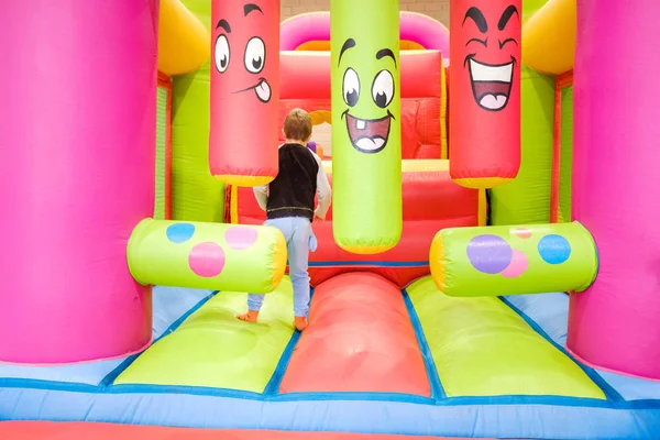 A boy enjoys jumping and bouncing in an inflatable castle at his — Stock Photo, Image