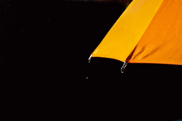 Paraguas multicolor bajo gotas de lluvia aisladas en negro como respaldo — Foto de Stock