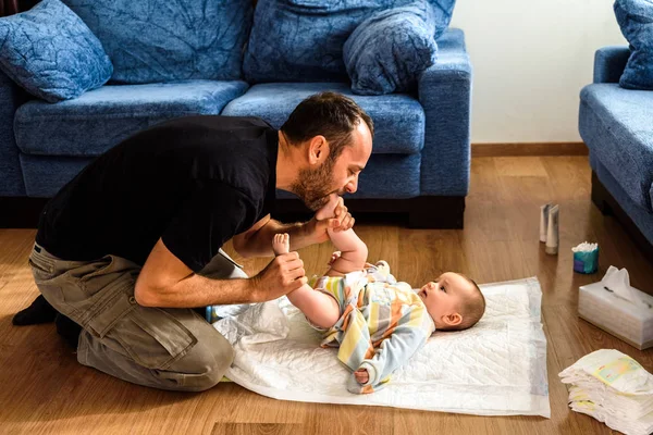 Padre cambiando el pañal sucio de su hija en la sala de estar f — Foto de Stock