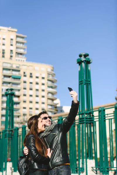 Couple of tourists embraced making themselves a selfie photo in — 스톡 사진