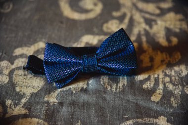 Yatağın üzerinde mor erkek papyonu.