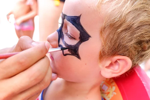 Boy painting his face with a superhero mask preparing for Hallow — Stock Photo, Image