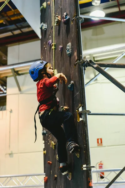 Kind op de muren van een klimwand met behulp van een veiligheidsgordel — Stockfoto