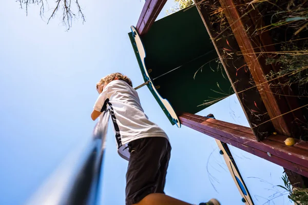 Young boy enjoying an outdoor park throwing himself through a me — Stock Photo, Image