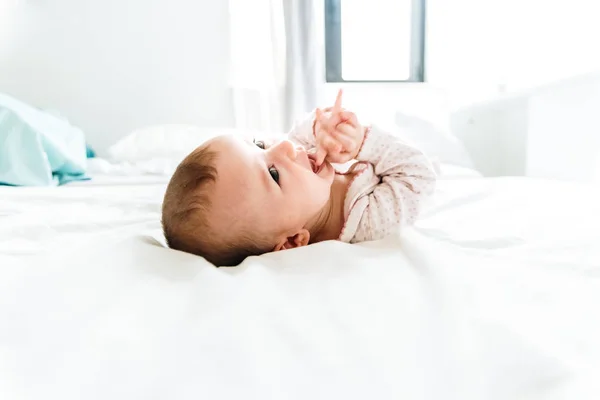 6 month old baby looking at camera in the morning lying on the b — Stock Photo, Image