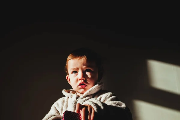 Retrato de bebé grave aislado con fondo oscuro . — Foto de Stock