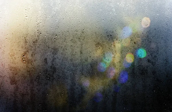 Beams of lights through a wet glass on a dark night, background — Stock Photo, Image