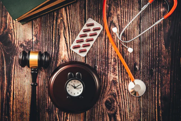 Gavel and stethoscope on wooden background, dark environment. — 스톡 사진