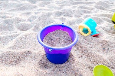 Kum havuzunda plastik oyuncak kovalar ve kürekler