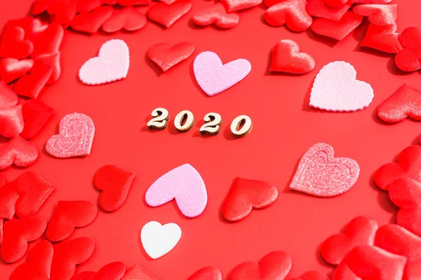 Ano 2020 em letras de madeira cercada por corações vermelhos em um romance — Fotografia de Stock