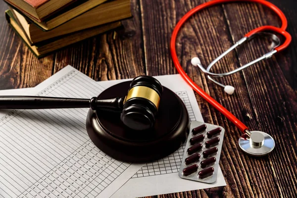 Stethoscope, books, pills and judge gavel seen from above. — Stock Photo, Image