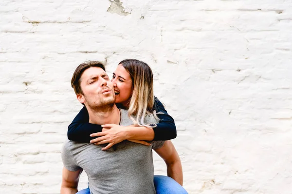 Pareja joven celebrando su amor con besos divertidos y caricias — Foto de Stock