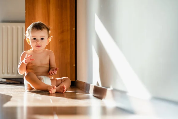 Bebê se divertindo batendo palmas sentado no chão do quarto . — Fotografia de Stock